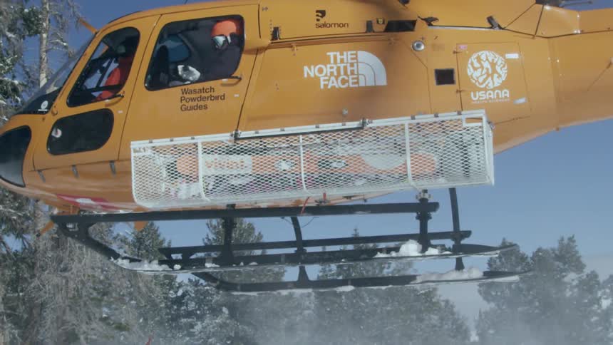 Orange helicopter takes off on a snowy day