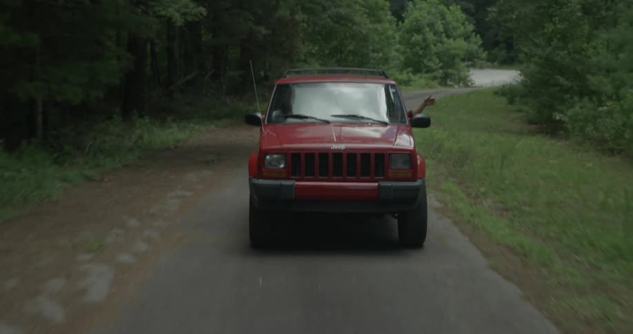 A red truck drives around the road
