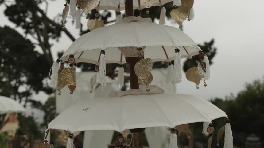 The ornament is hanging outside and has gold leafs all over