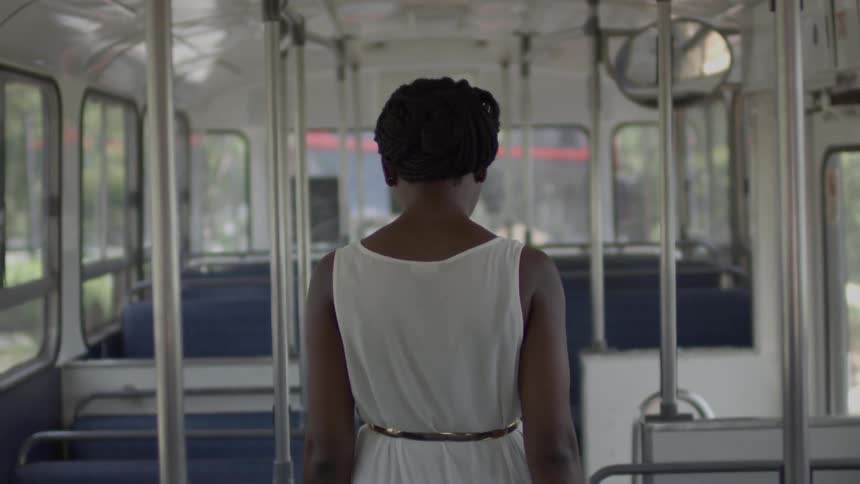 A woman is walking in an empty bus