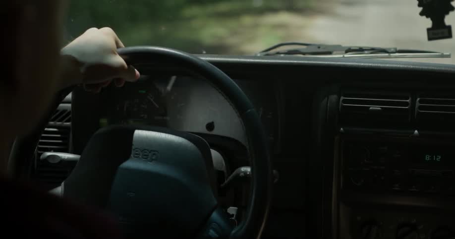 A man is steering his vehicle as he drives