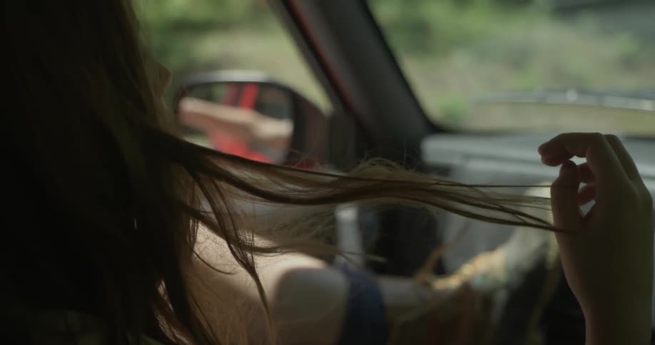 A woman rides in the passenger seat of a vehicle