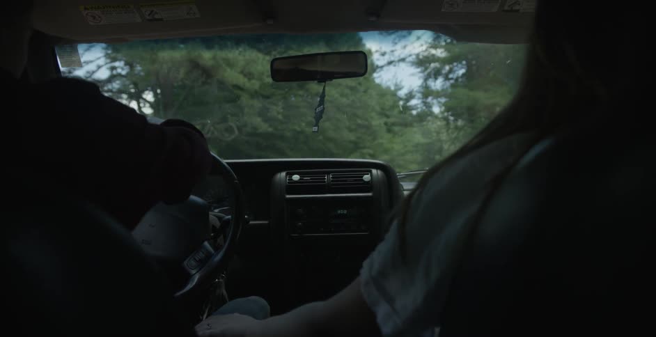 Two people are driving on a cloudy day