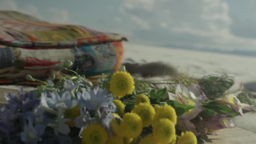 The sand is covered with flowers and blankets
