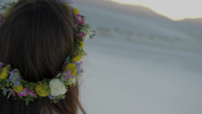 Woman wearing flower wreath on head standing in mountain wilderness