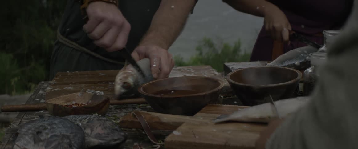 Scales are cut off of fish with knives