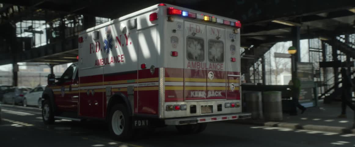 An ambulance races under the train