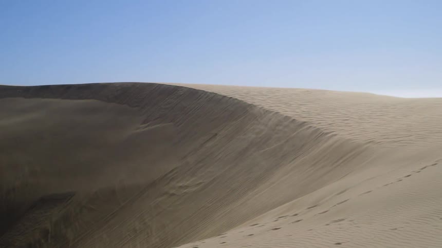 Sand falls down a dune in the desert