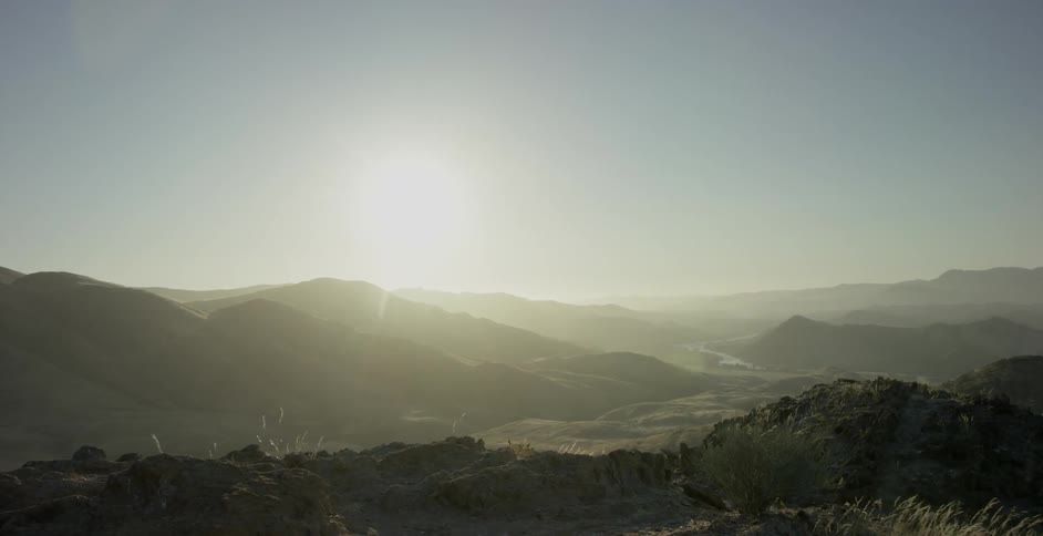 The sun is rising above the windy mountains