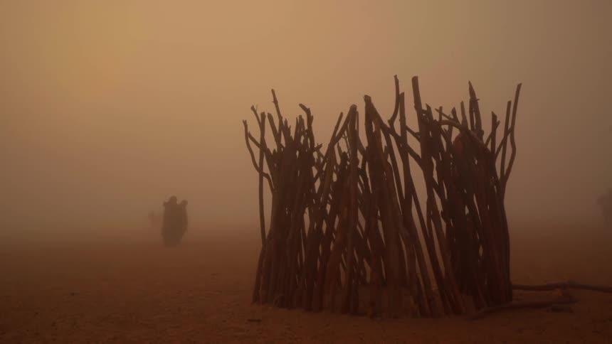 People walk through a sandstorm