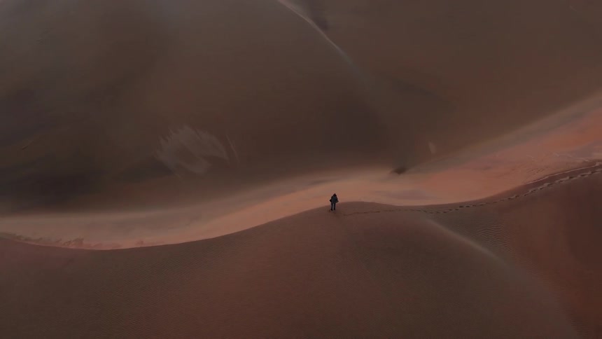 The desert below only has one person hiking