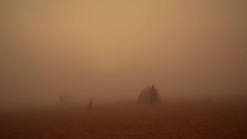 People are walking around in a sand storm in the desert