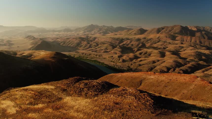 A hiker stands on a mountain on a clear day