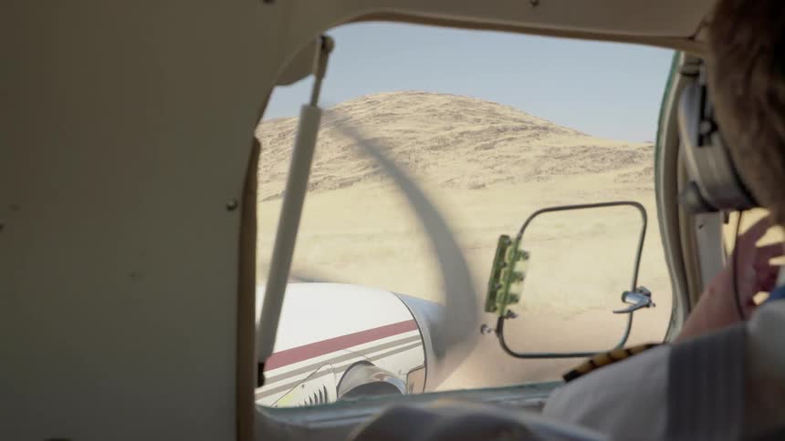View looking out of an airplane window as it takes off