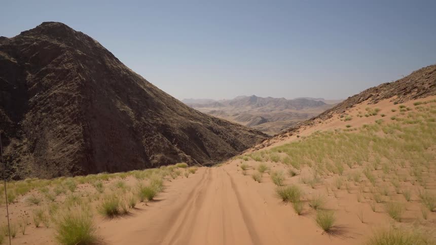 The small dirt trail leads towards the mountain