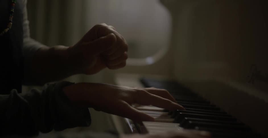 Two people play a piano