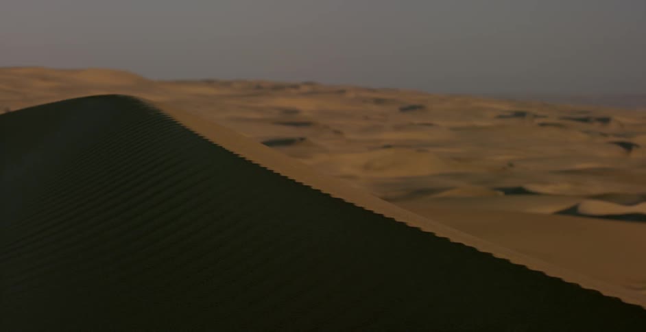The tall sand dunes give shade in the desert