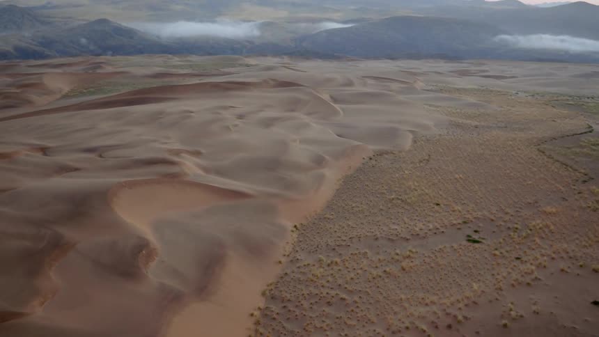The desert below is hilly and foggy