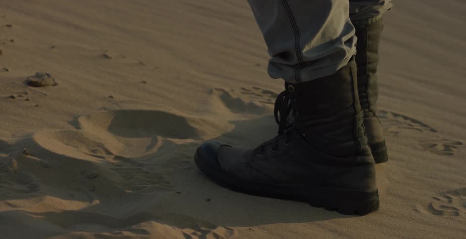 Pair of work boots create footprints in the sand