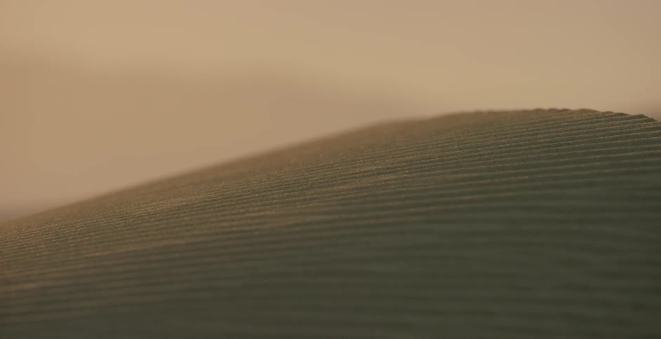 A sand covered hill is being filmed