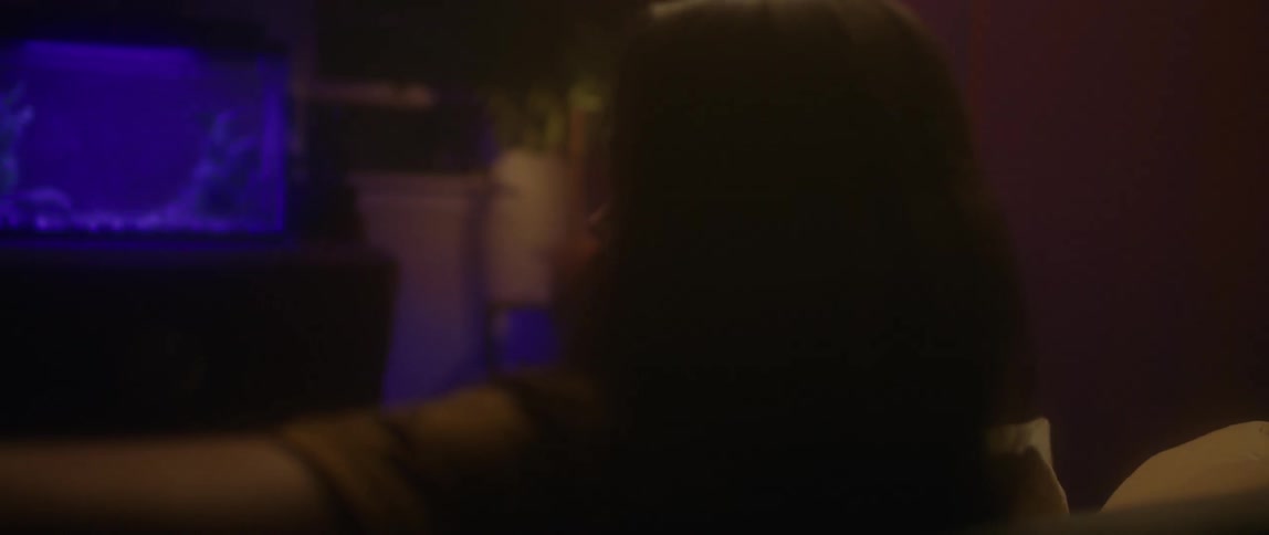 Bearded man sits across the room from an aquarium