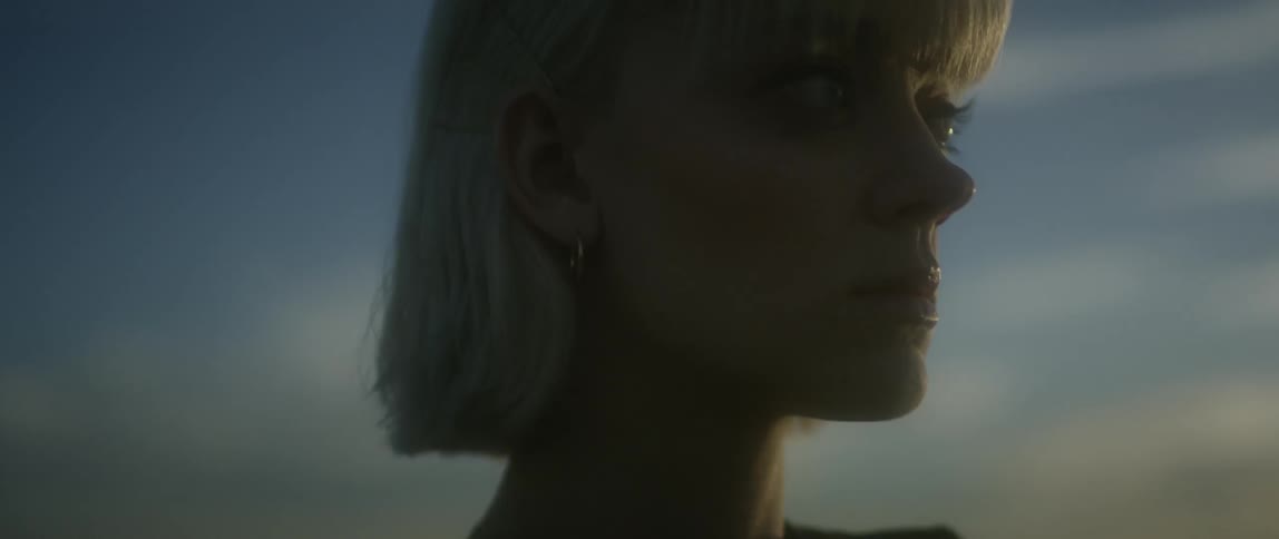 Woman with short blond hair blinks her eyes and swallows
