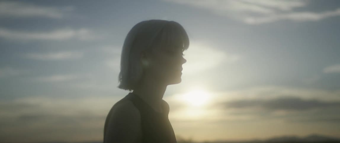 A woman is walking slowly as the sun sets