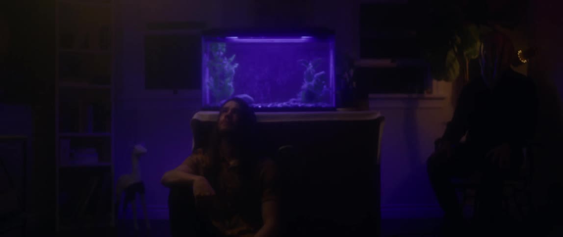 A man sits by an aquarium