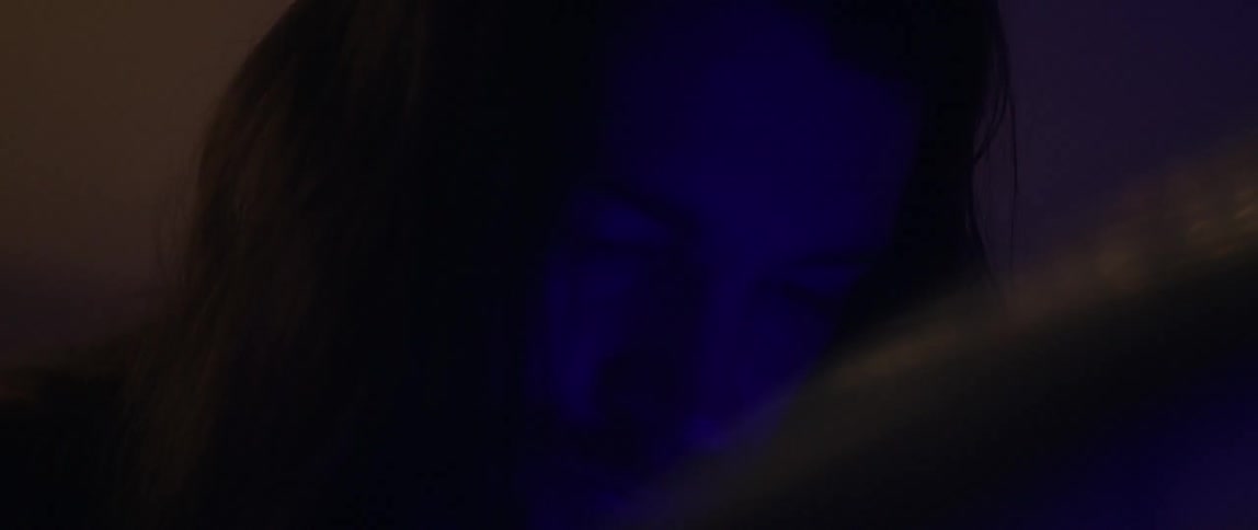 A man is looking down at a purple light