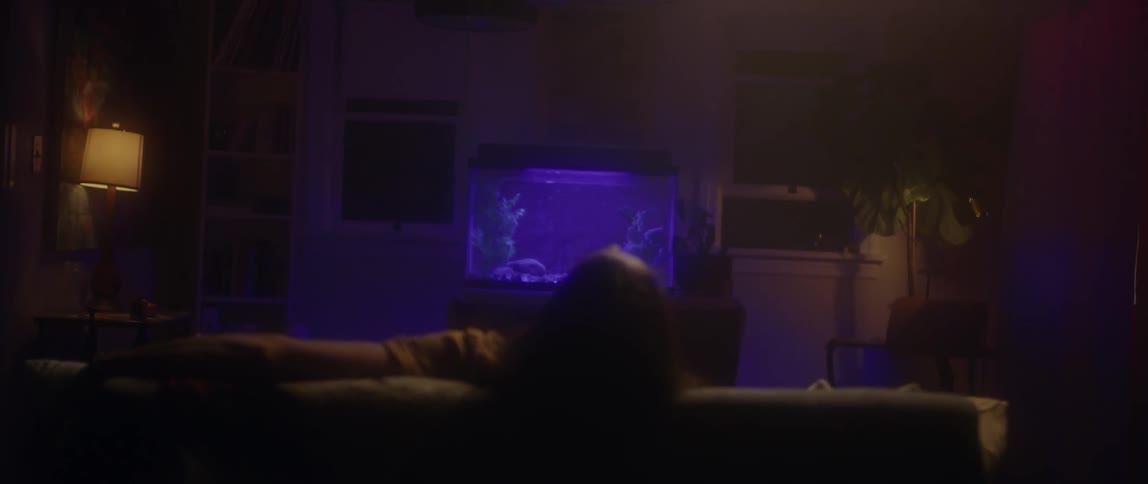 A man is sitting on the couch leaning back