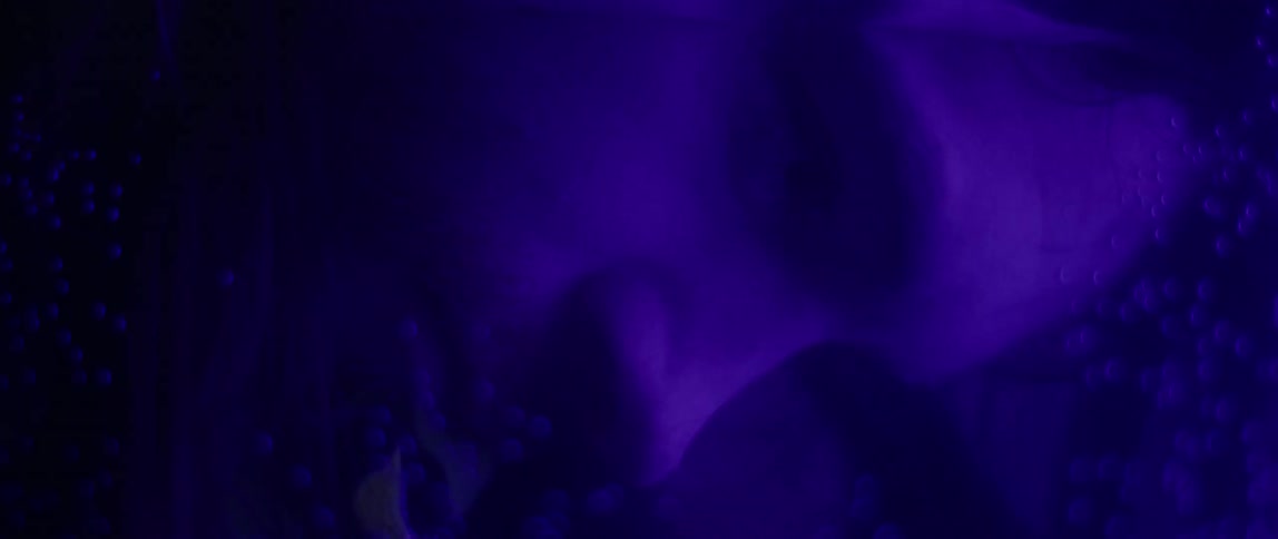 A man submerges his face in a fish tank