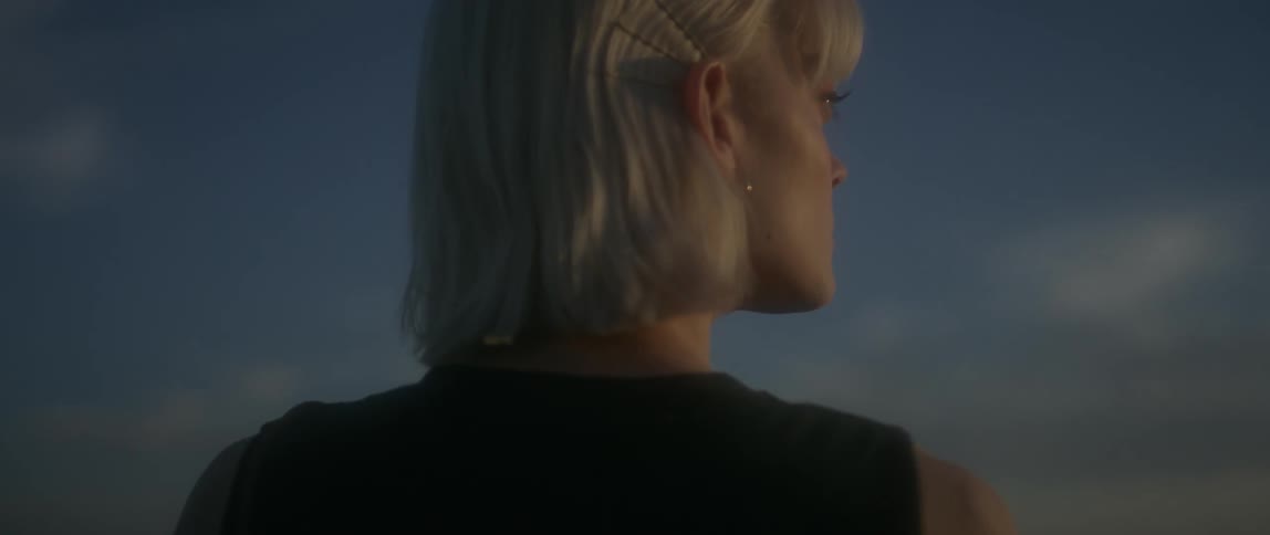 Woman stands outside looking to her right
