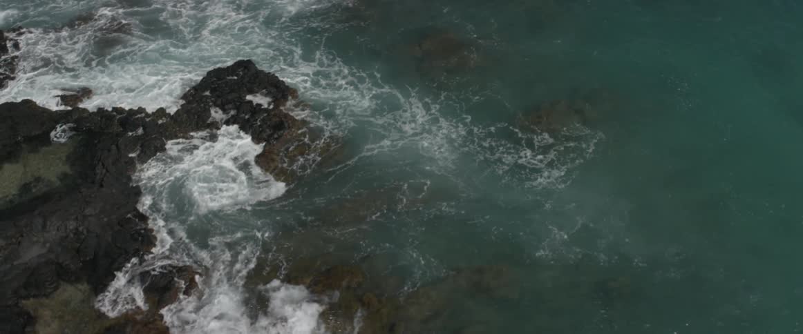 Ocean waves crash into a rocky shore