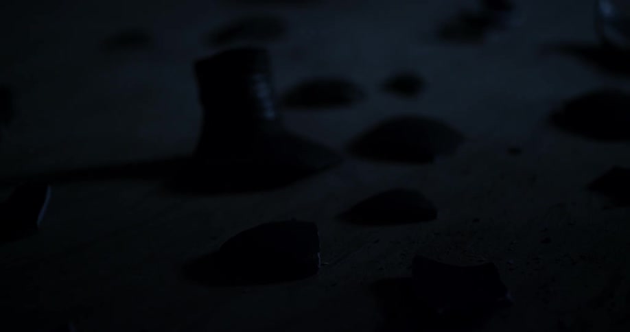 Light flashes over debris on the sand