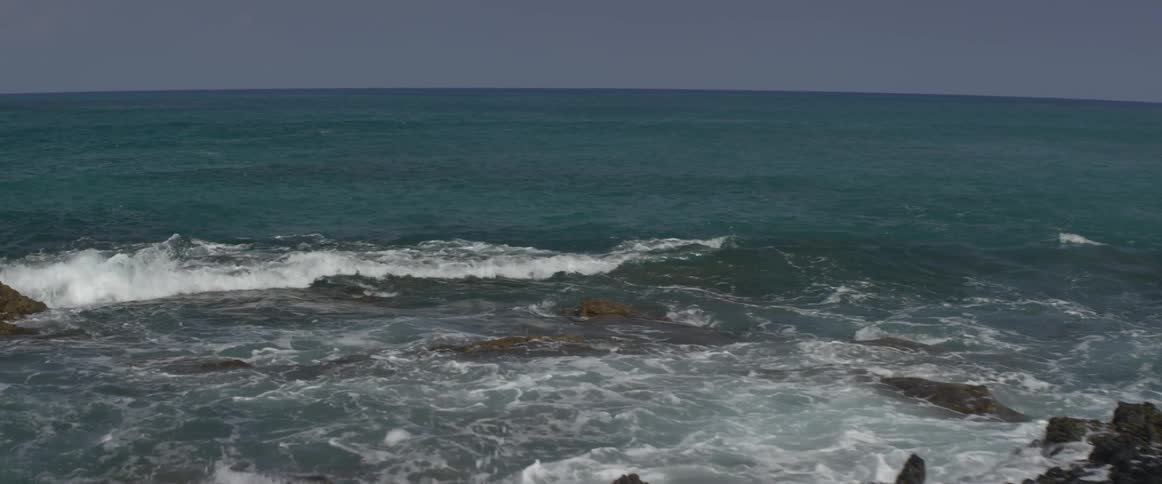 Rocks line the shore with rough waters