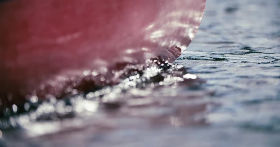 Sunlight reflects off the side of a small boat in the water