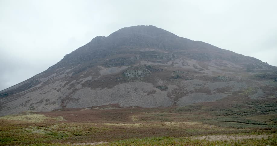 The tall mountain is brown and green