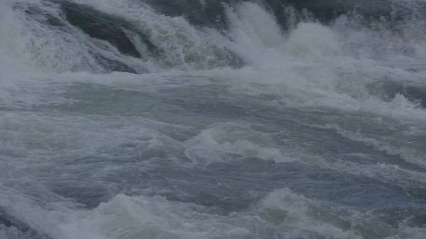 Waves cascade down a rock formation into a river