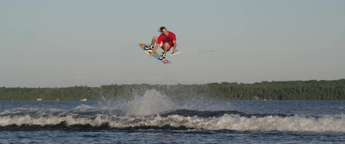 A skier jumps a wave on a lake