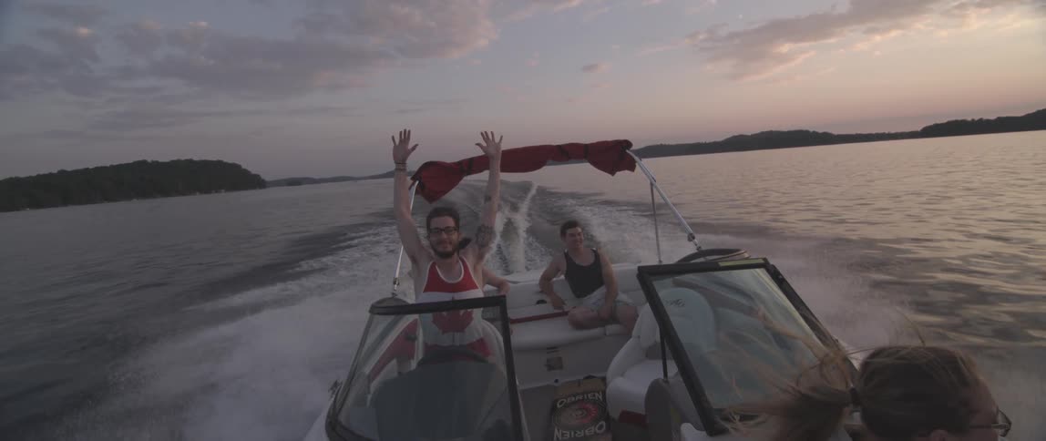 People boating on a lake at sunset