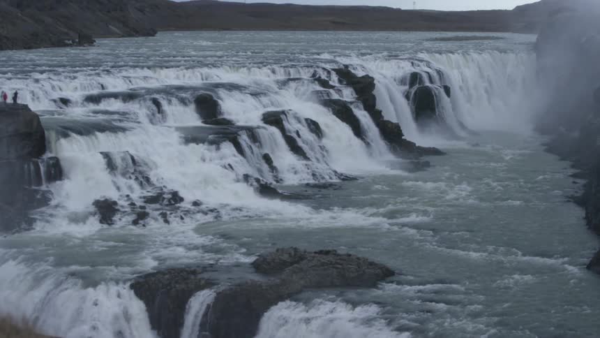 Water flows down rocks into the river below