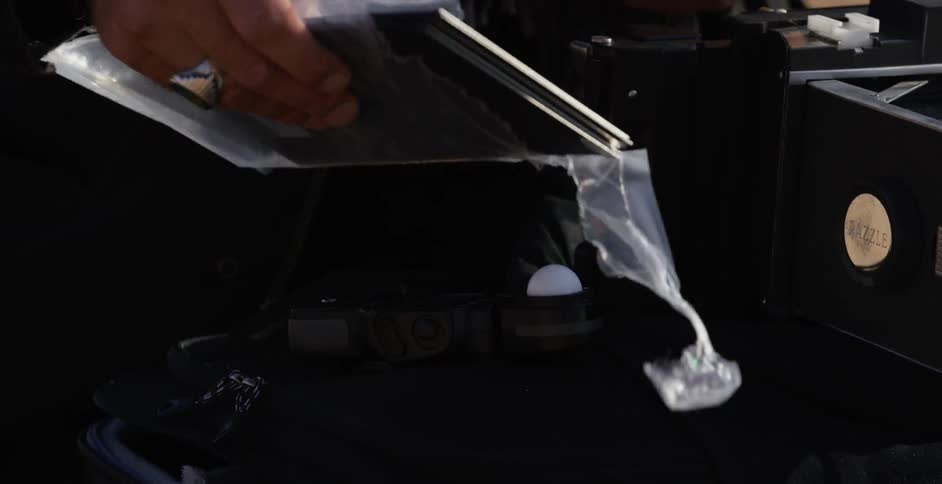 A man tears plastic off of something