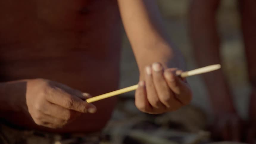 A man assembles a tool using sticks