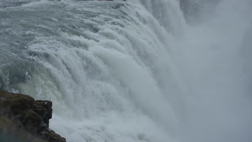 A waterfall gushes over a cliff