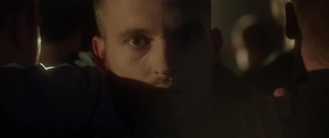 A man trapped in a crowd is staring