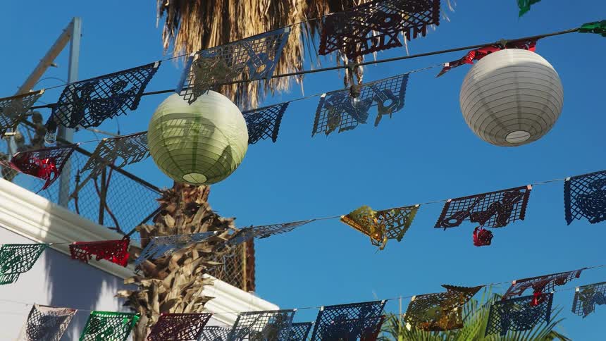 Lanterns and banners strung between buildings are swaying in the breeze