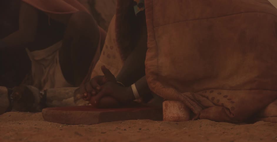 A villager is crushing something with a rock