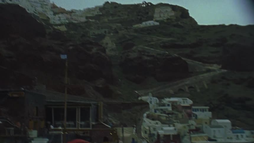 Houses line the side of a mountain and coastal town