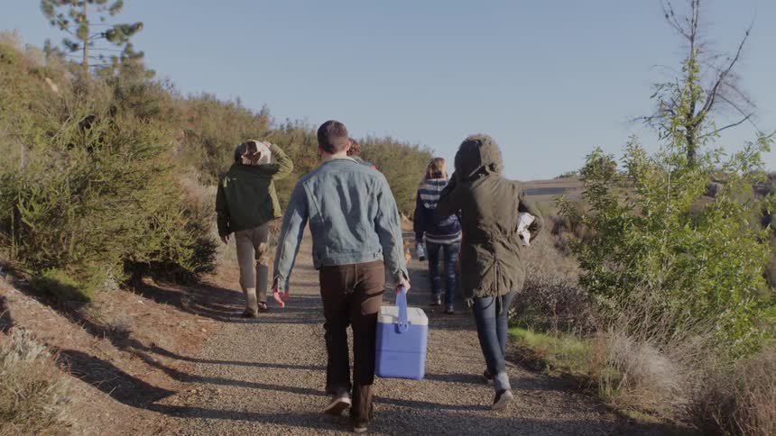 A group of people walk up a hill together