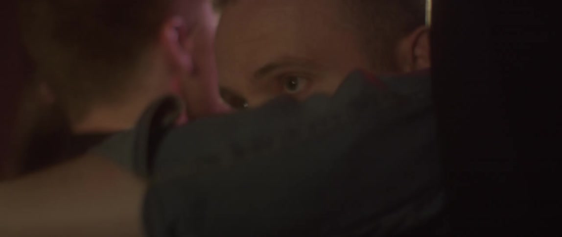 A man barges through people in a dance club